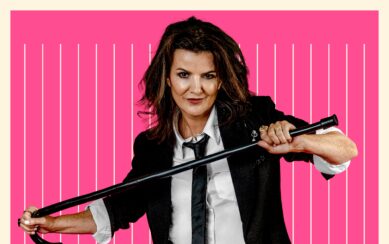 Deirdre O'Kane posing with a cane against a pink background