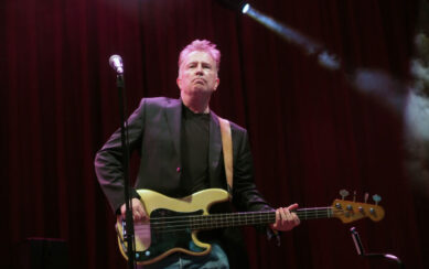 Tom Robinson performing on stage with guitar 