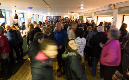 A packed audience in the foyer of the theatre 