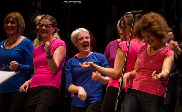 A group of women laughing and dancing on stage