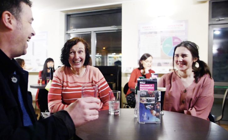 Three patrons laughing in the bar of the theatre
