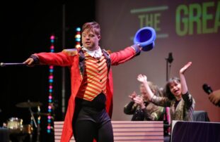 Performer on stage dressed as The Greatest Showman