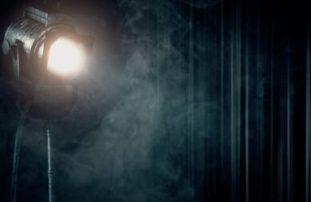 A photograph of a spotlight illuminating smoke on a stage