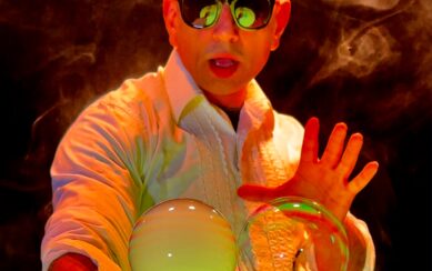 Performer wearing sunglasses creating bubbles 