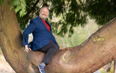Comedian sitting on the branch of a tree 