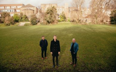 Members of Bell X1 standing in a green meadow