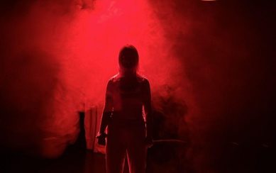 Silhouette of a woman in smoke, in red and black tones. 