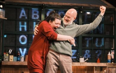 A man and a woman celebrating, her hugging him and him punching the air