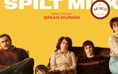 Family sitting against a yellow background