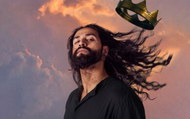 man with long hair blowing in the wind and his crown blowing away 
