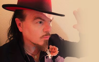 Close up photograph of performer Jack Lukeman wearing a top hat