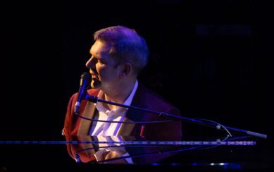 Pianist sitting at piano with microphone 