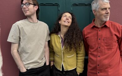 Picture of three people staring in three different direction against a green door 