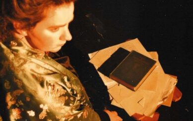 Woman sitting at table with books and papers on it 