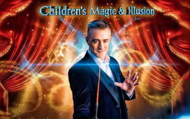 A magician in a suit is holding a magic wand.