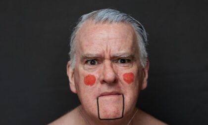 A photograph of Mikel Murfi. He is wearing make-up which makes him look like a marionette 