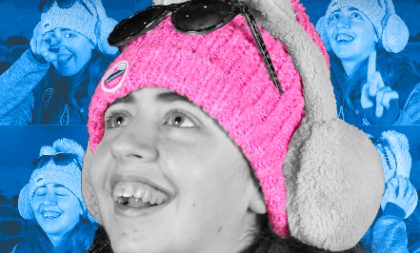 A photograph of a girl smiling and looking up. She's wearing a pink hat, earmuffs and sunglasses on top of her head A photograph of a girl smiling and looking up. She's wearing a pink hat, earmuffs and sunglasses on top of her head