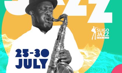 Tony Kofi plays the saxophone in front of a green and yellow jazz-inspired graphic design Tony Kofi plays the saxophone in front of a green and yellow jazz-inspired graphic design