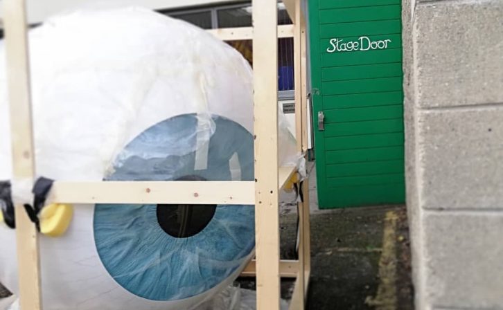 A large eyeball stage prop at the stage door.