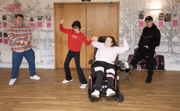 Four customers dancing in the theatre's foyer