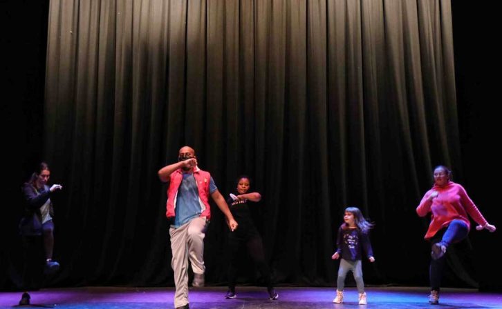 Five performers dancing on the theatres stage Five performers dancing on the theatres stage