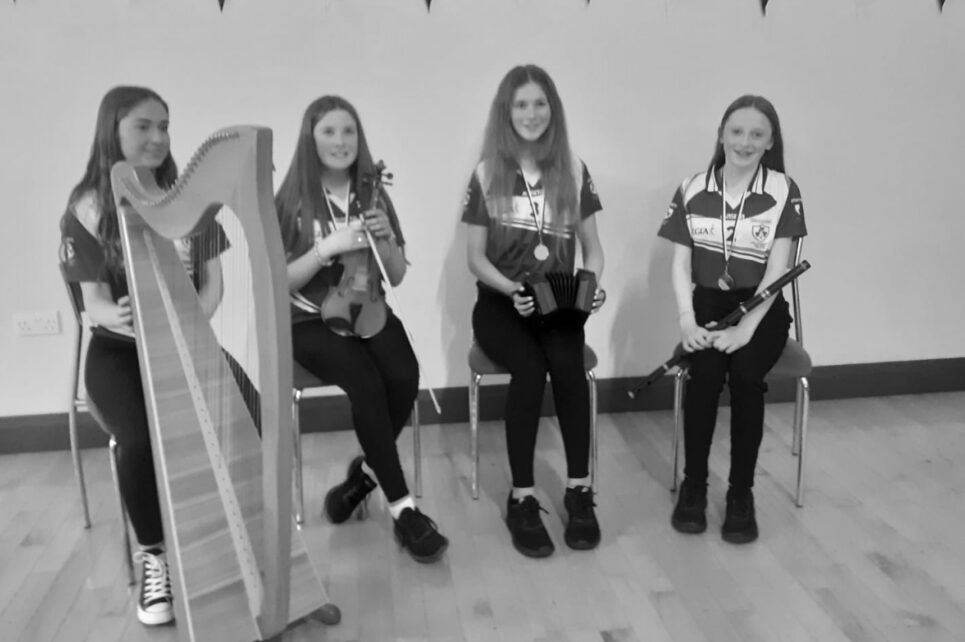 Four young girls with their instruments smiling for the photo