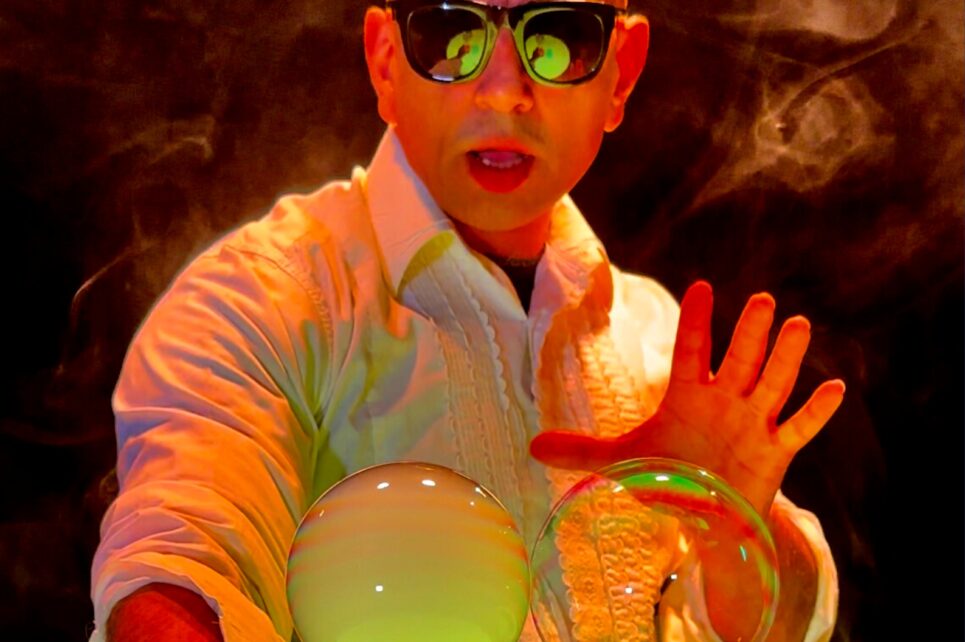 Performer wearing sunglasses creating bubbles 