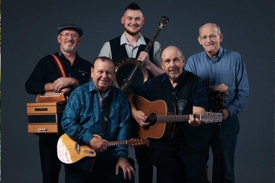 A portrait of the band The Fureys holding their instruments and smiling. 