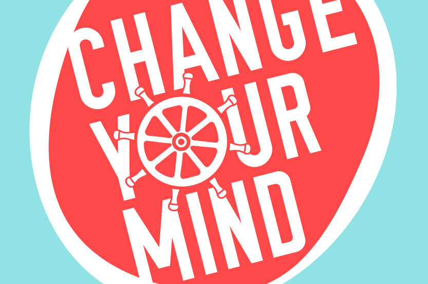 A circular logo of the change your mind event, with the words in white against a red background and a ship wheel replacing the letter O