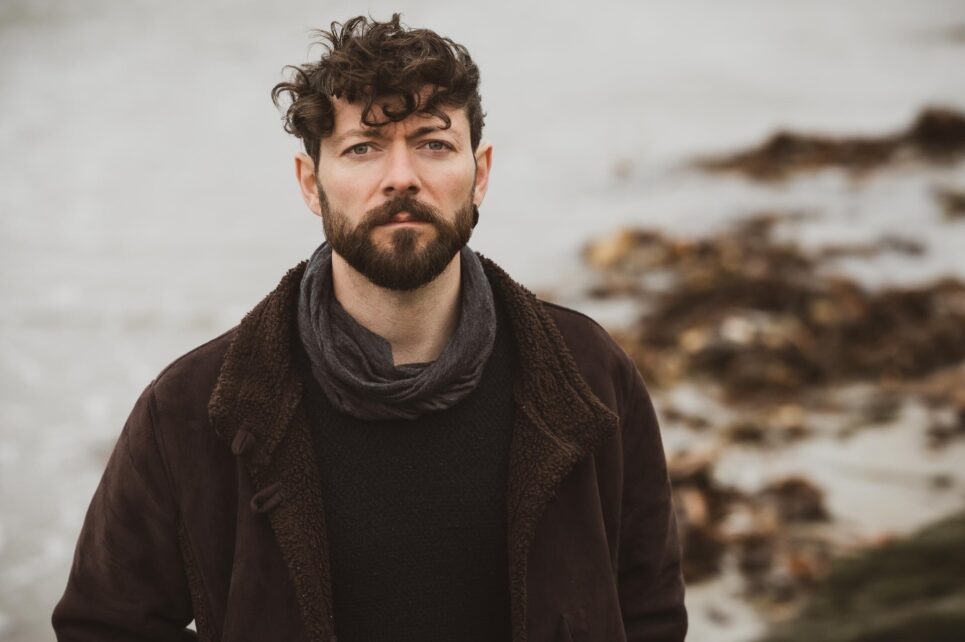 A photograph of Niall McCabe with a beach in the background