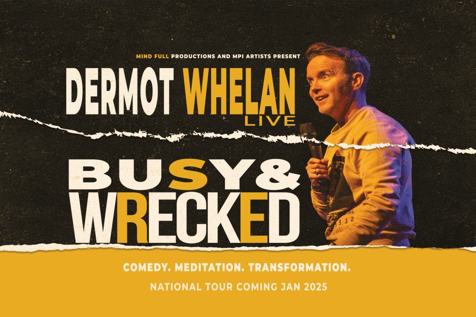 Comedian Dermot Whelan speaking into a microphone on stage