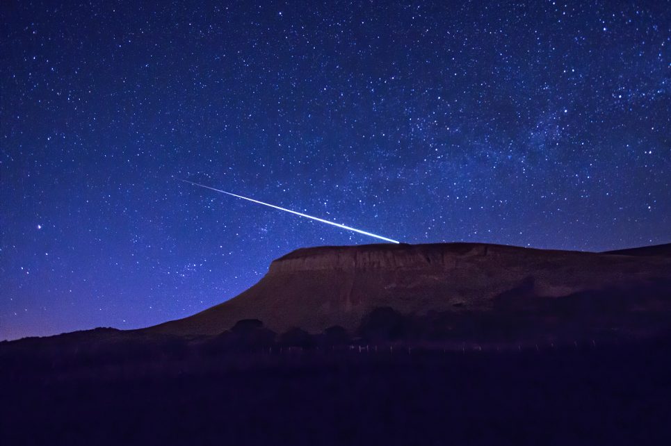 A photograph of Benbulben at nighttime with a meteor shooting across the sky behind it. A photograph of Benbulben at nighttime with a meteor shooting across the sky behind it.