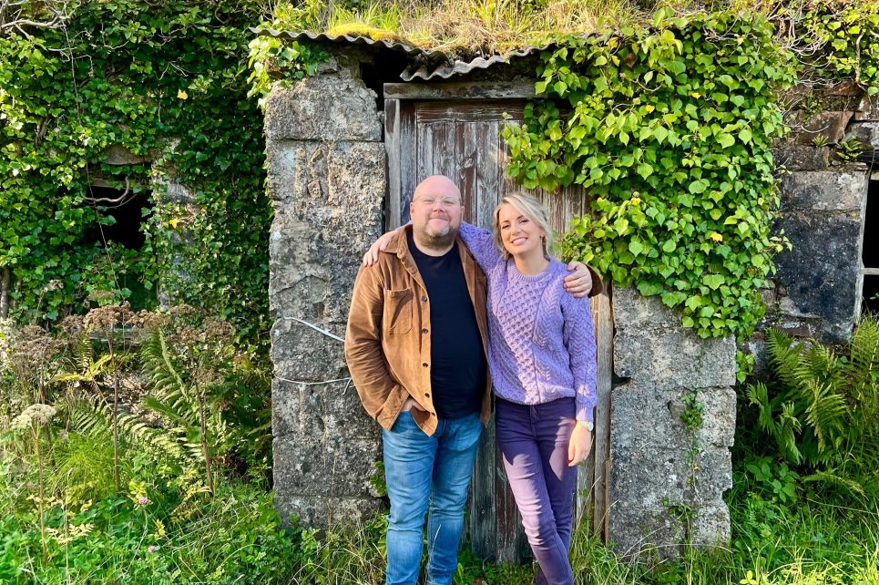 David Munnelly and Edwina Guckian posing for a photo by a stone wall