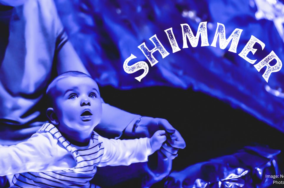 A blue-tinted photograph of a baby looking up in amazement. On the right is the word Shimmer.