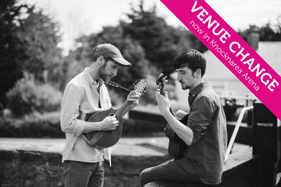 Black and white photo of two young men playing mandolins