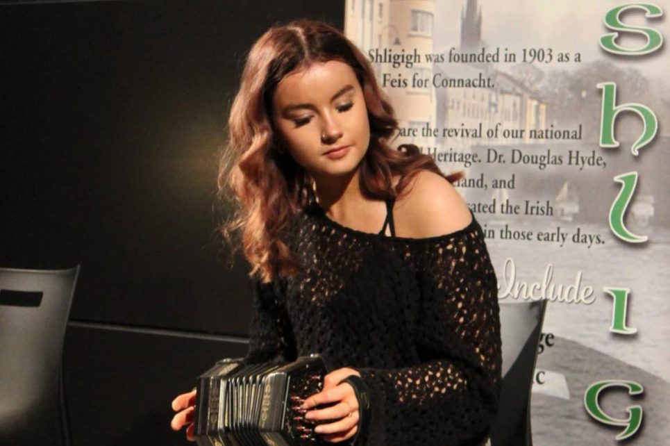 Girl sitting playing concertina