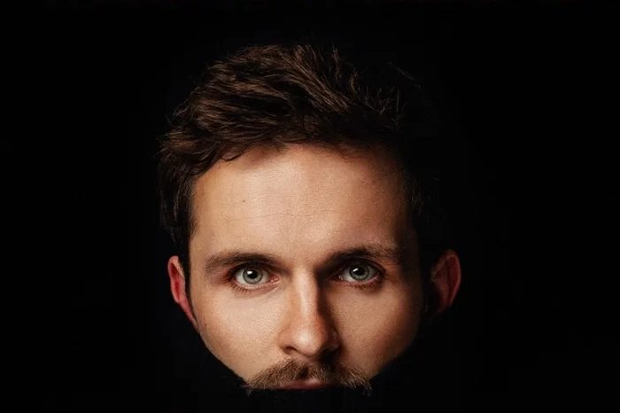 Image of comedian Vittorio Angelone's face against a back background with is mouth blacked out Image of comedian Vittorio Angelone's face against a back background with is mouth blacked out