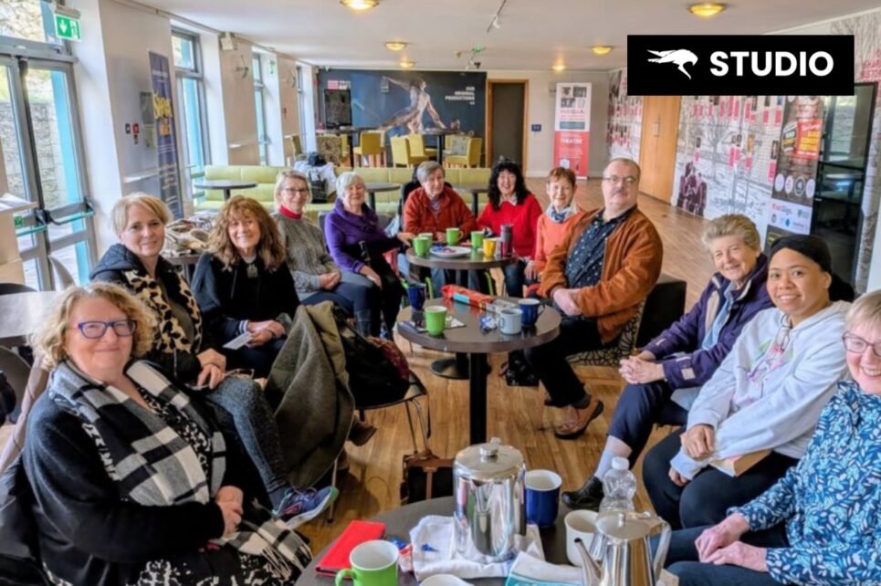 A group of people sitting and smiling for a photograph