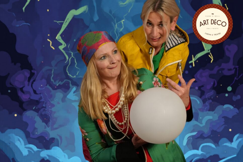 Two women leaning over a crystal ball 
