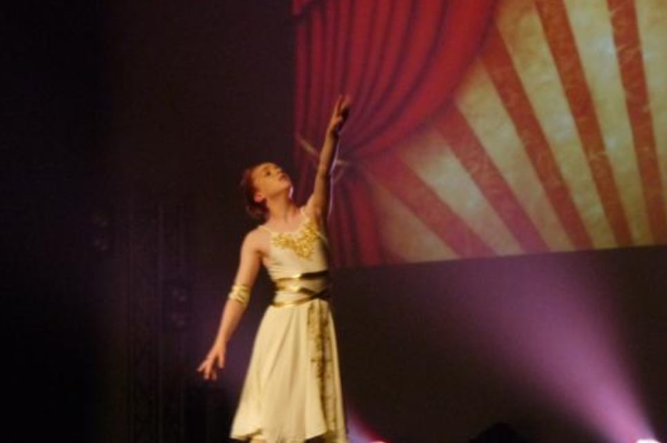 Performer reaching her arm up high