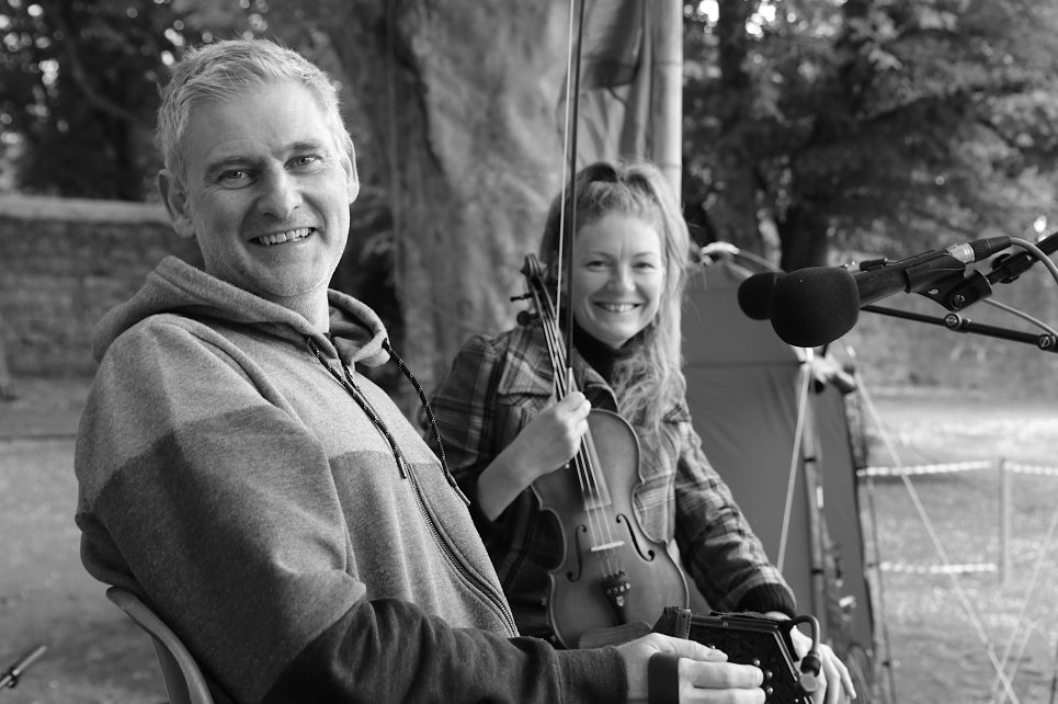 Musicians posing with their instruments in a park.