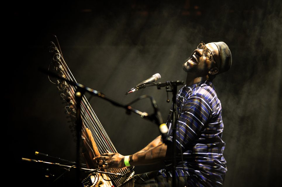 Artist Seckou Keita performing into a mic