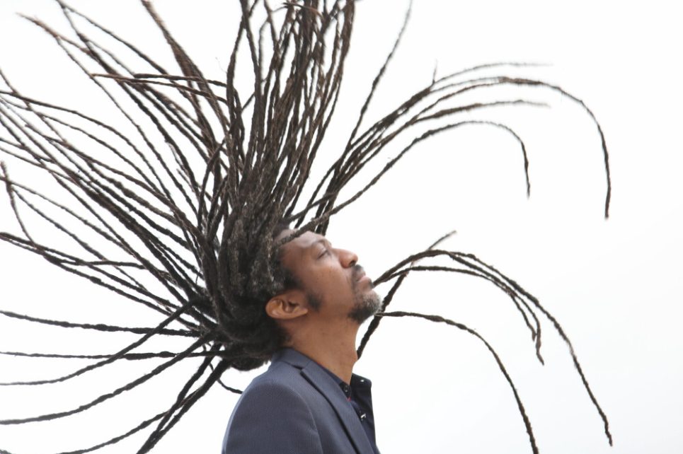 A profile photograph of Elio Villafranca throwing his head back.