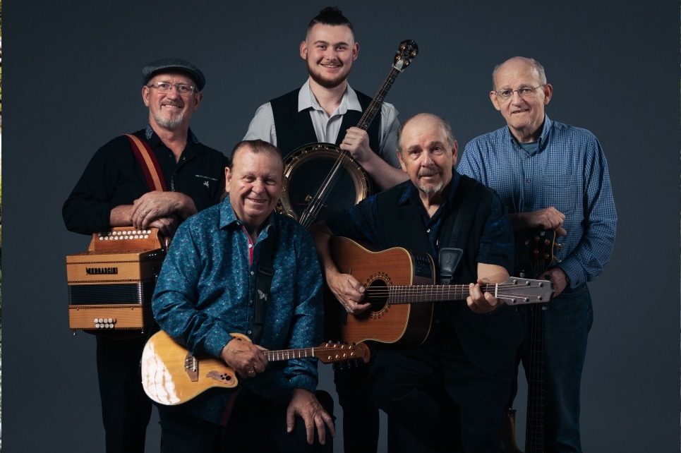 A portrait of the band The Fureys holding their instruments and smiling. A portrait of the band The Fureys holding their instruments and smiling.