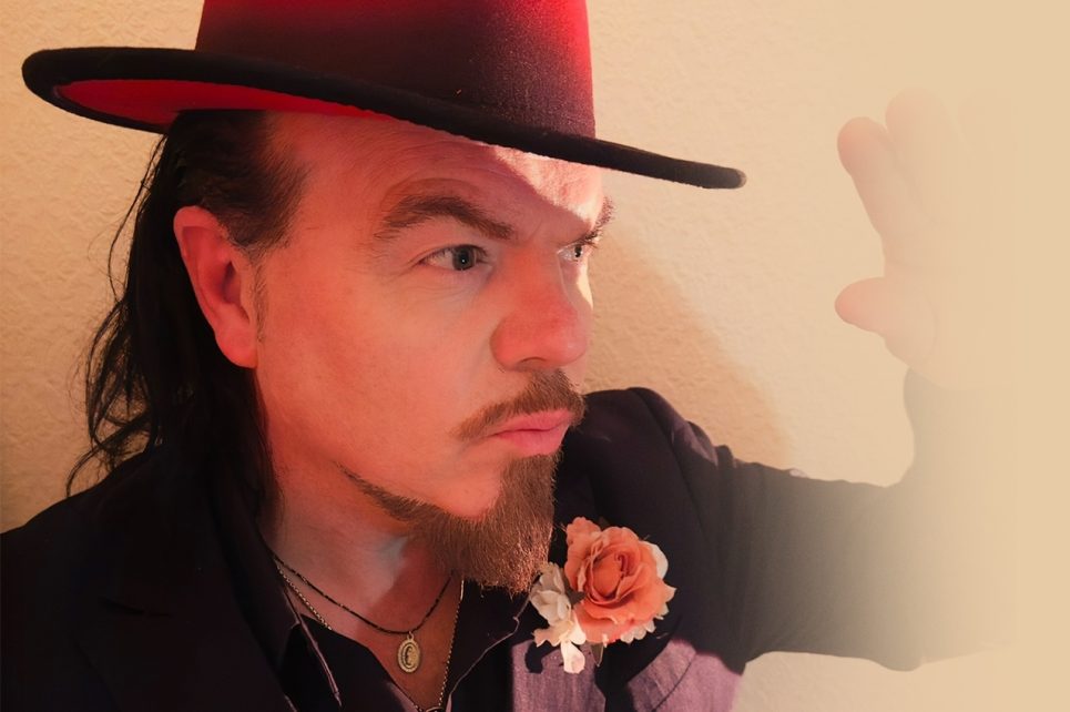 Close up photograph of performer Jack Lukeman wearing a top hat