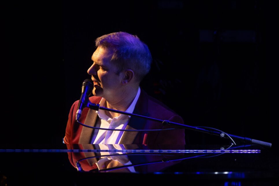 Pianist sitting at piano with microphone