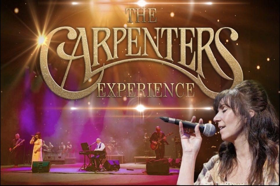 The background is an image of the band performing. On the right there is a woman singing and facing the left. In front of that is large gold text which reads "The Carpenters Experience" The background is an image of the band performing. On the right there is a woman singing and facing the left. In front of that is large gold text which reads "The Carpenters Experience"