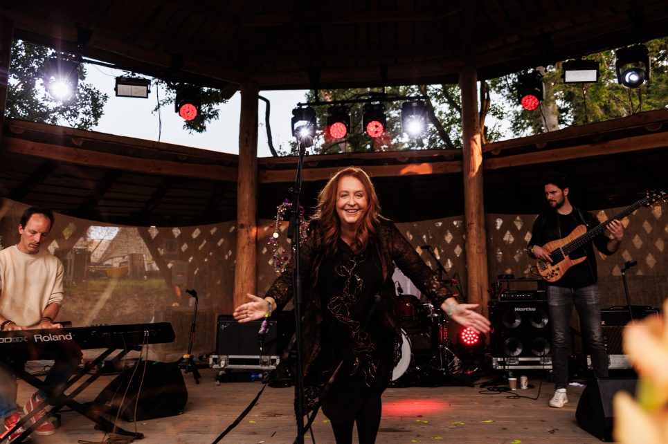 Mary Coughlan smiling in the middle of a wooden outdoor stage Mary Coughlan smiling in the middle of a wooden outdoor stage