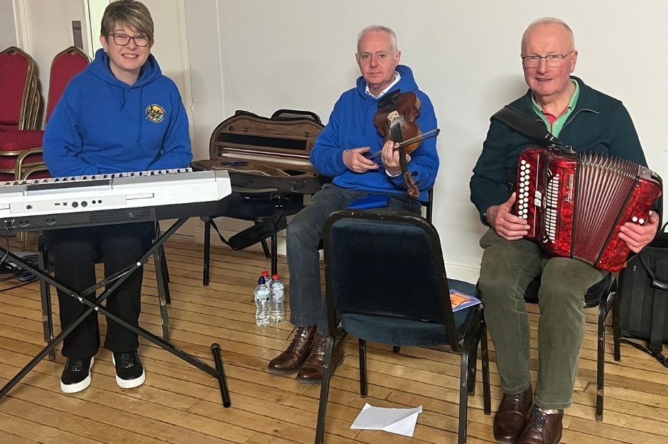 Michelle Gallagher, Brian Mostyn, and John McLoughlin posing with their instruments Michelle Gallagher, Brian Mostyn, and John McLoughlin posing with their instruments