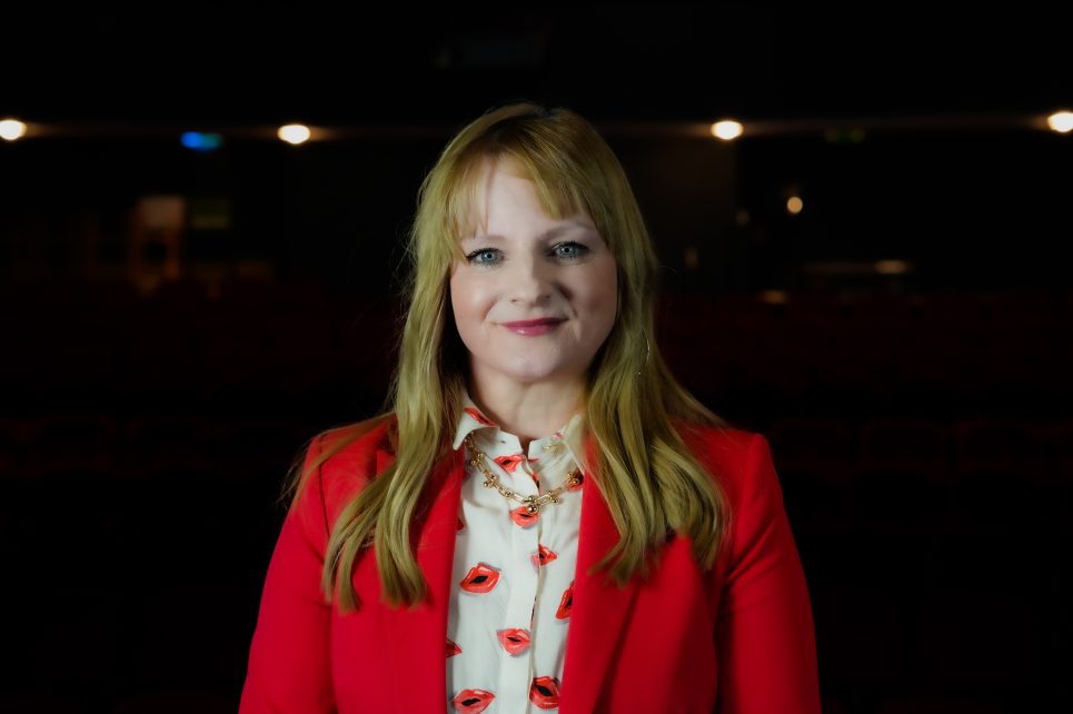 A portrait of a smiling Niamh on a dark background A portrait of a smiling Niamh on a dark background